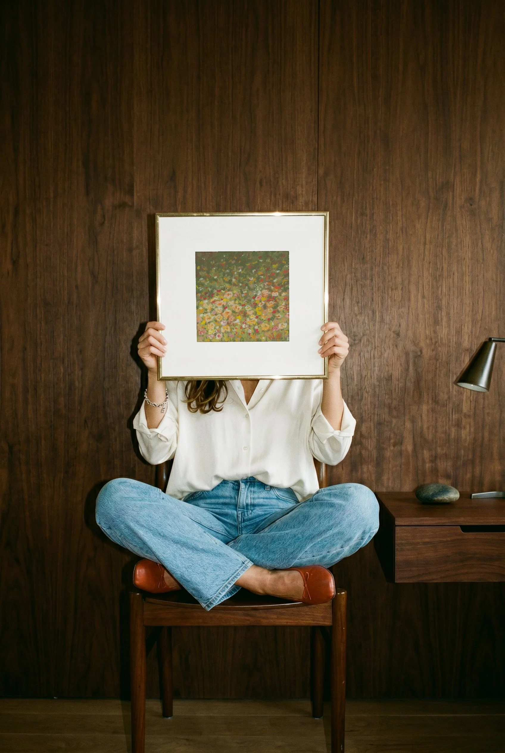 Melted Meadow framed art print in gold frame, abstract floral painting, person holding print in front of face