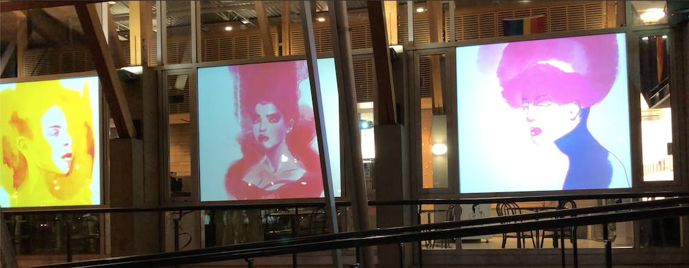 Three digital screens displaying stylized portraits of women with different hair colors and styles in an indoor setting.