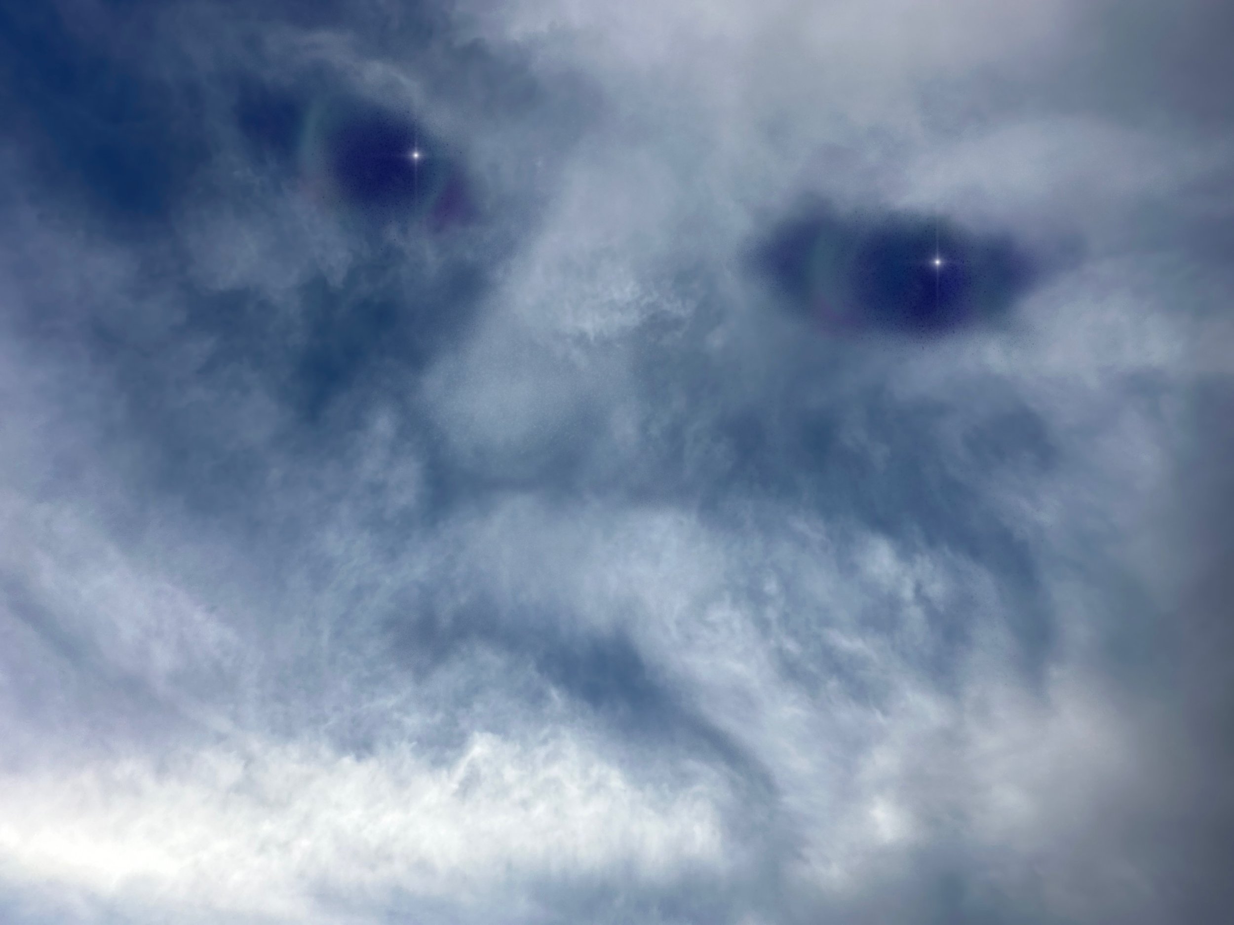 A partly cloudy sky with sun rays peeking through the clouds.