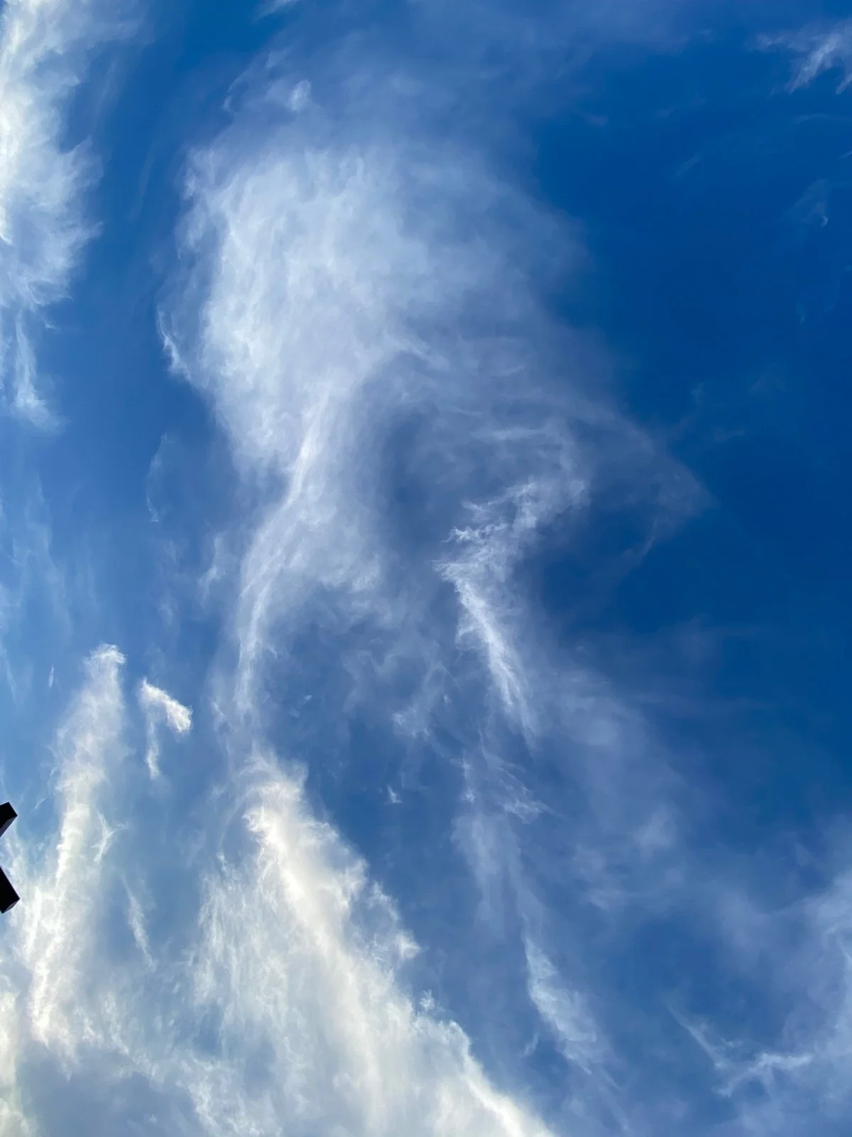 Blue sky with wispy white clouds scattered across.