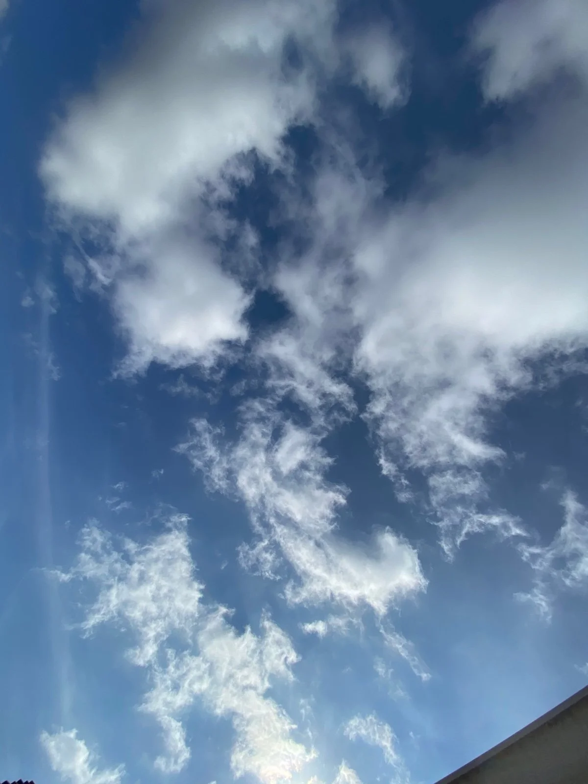 A blue sky with scattered white clouds, partly cloudy weather.