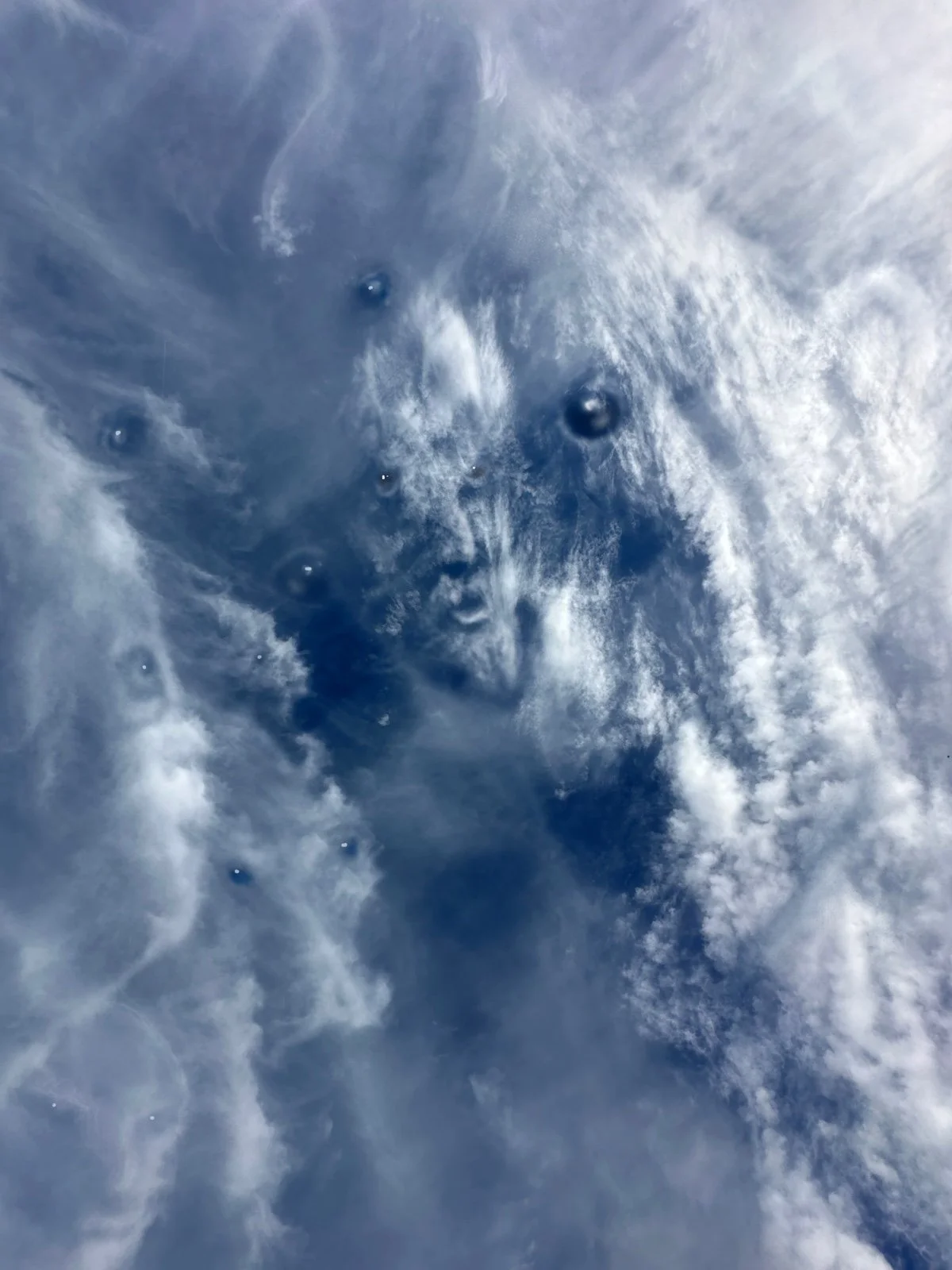 Close-up of cloudy sky with blue sky visible through the wispy clouds.