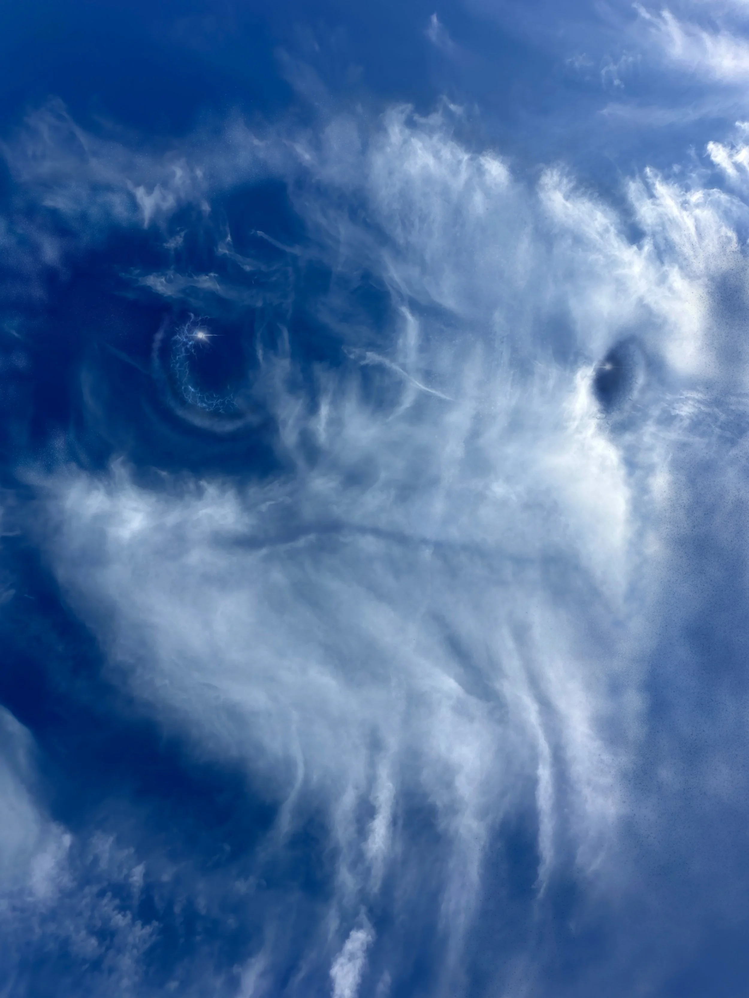 Blue sky with wispy white clouds.