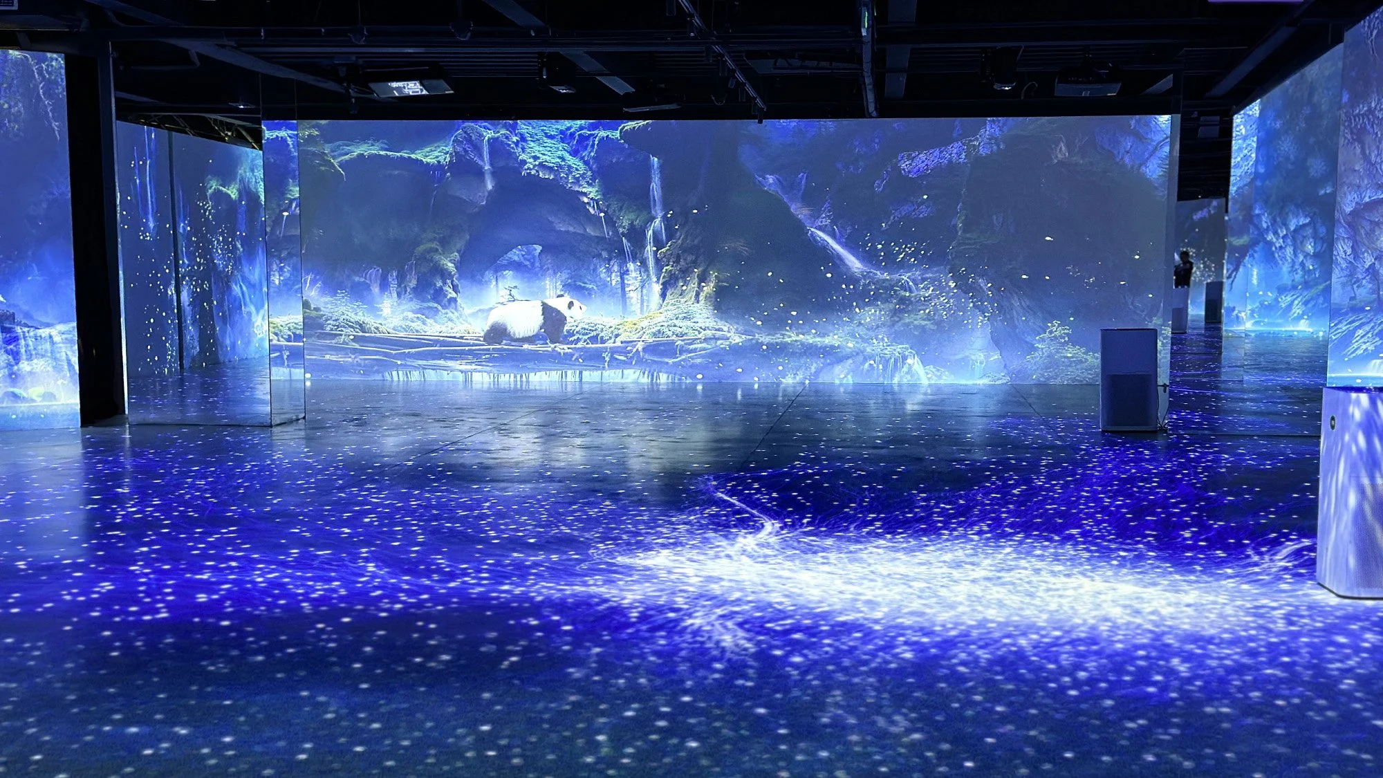 "Panda Planet" immersive exhibit: Digital scenic landscape with illuminated waterfalls, greenery, and blue-purple glowing lights.