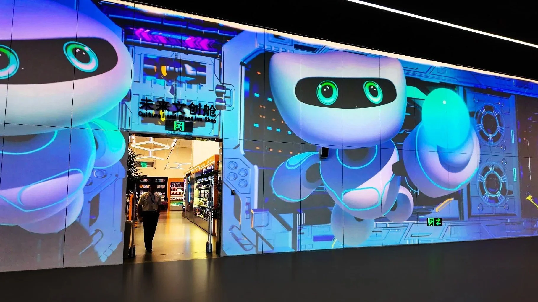Shenzhen Science and Technology Museum: Digital wall with cartoon robots outside the Cultural Creative Shop entrance.