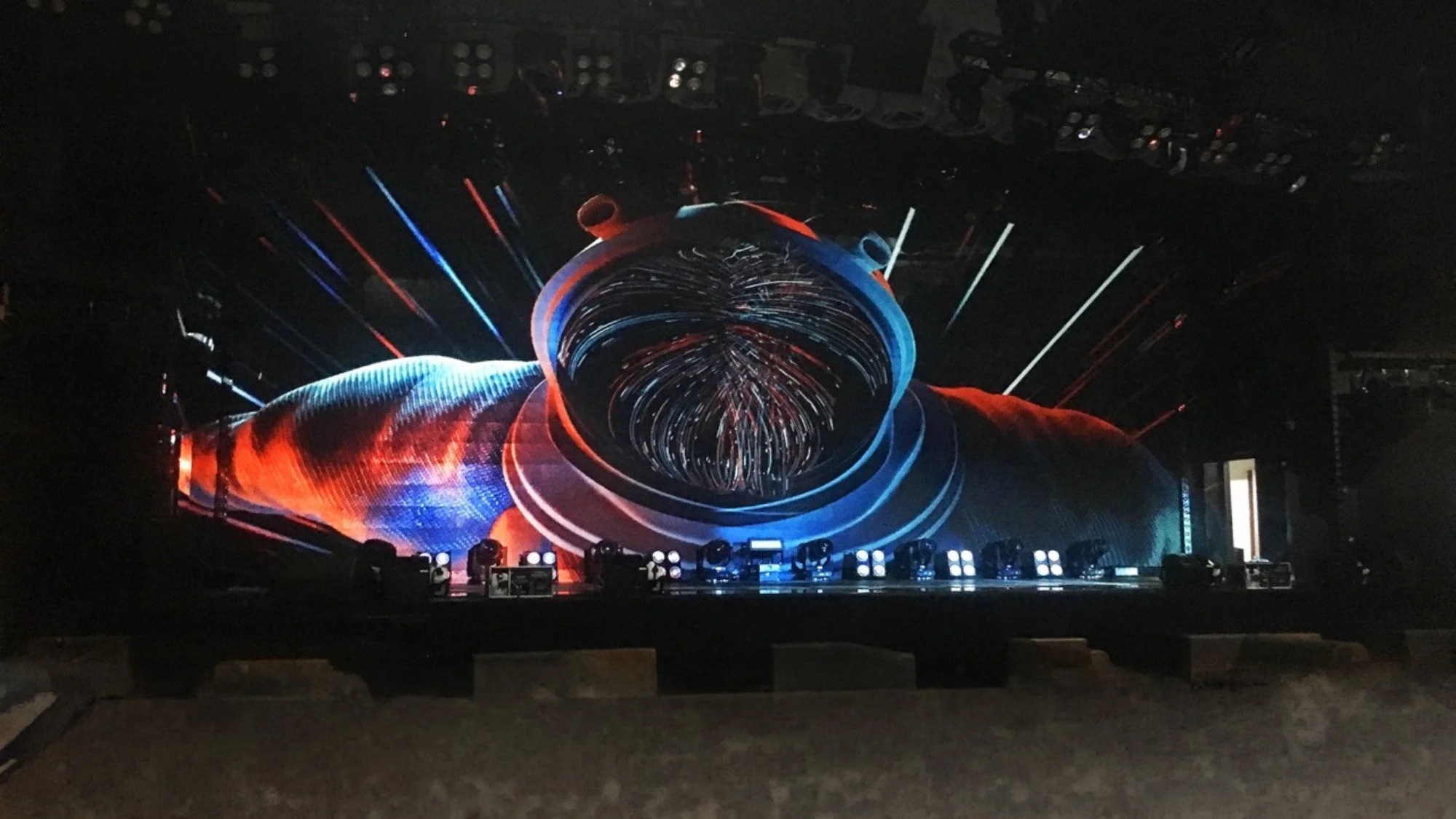 "Xi'an Garuda Project": Large digital stage with swirling red, blue, and white light projections creating a vortex tunnel effect.