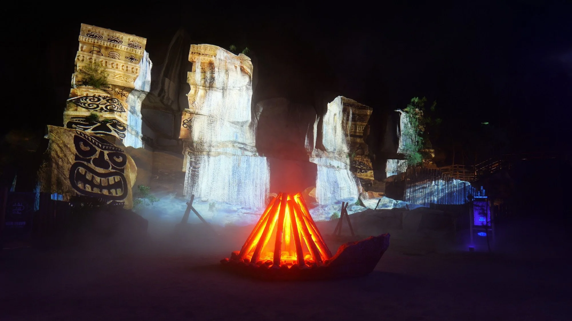 "Planetary Story: Blue Tears" multimedia drama in Pingtan: Tribal artwork projected on rocks with a campfire in foreground.