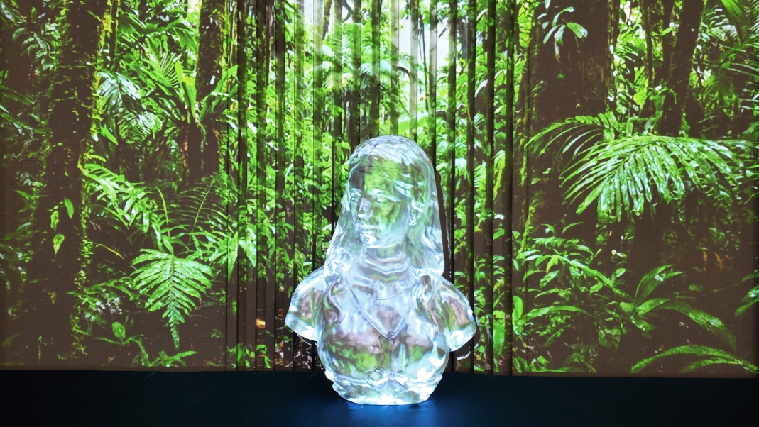 Ai Mapper display: Precision mapping onto an ice sculpture of a woman's bust against a rainforest background.
