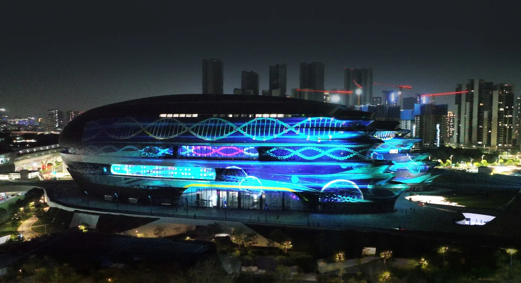 Shenzhen Science and Technology Museum: Futuristic building with glowing blue-purple lights against city skyline at night.