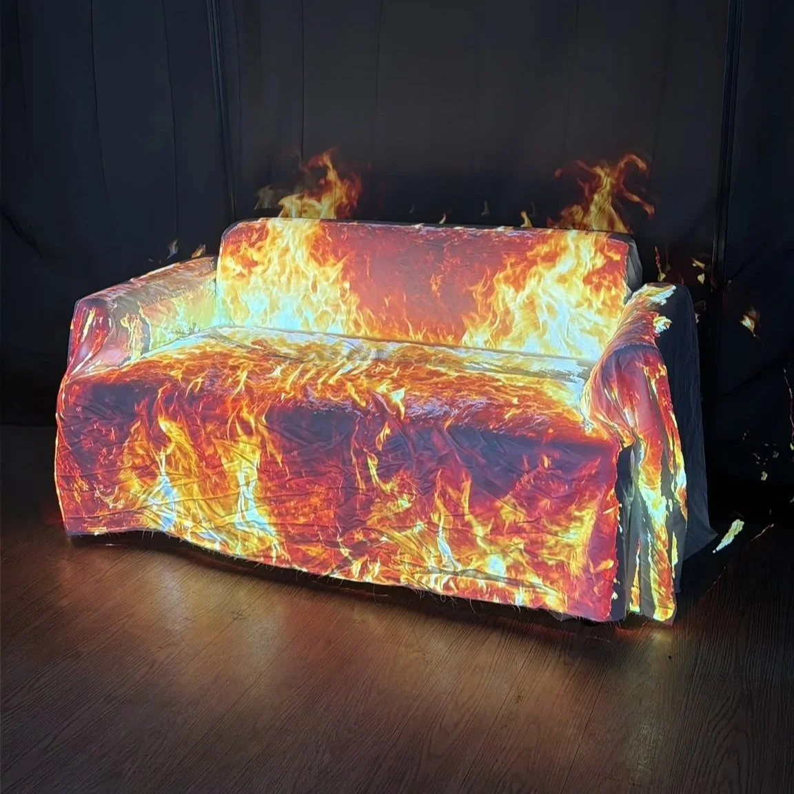 Ai Mapper software demo: Vibrant orange and yellow flame projection mapped onto a couch against black background.