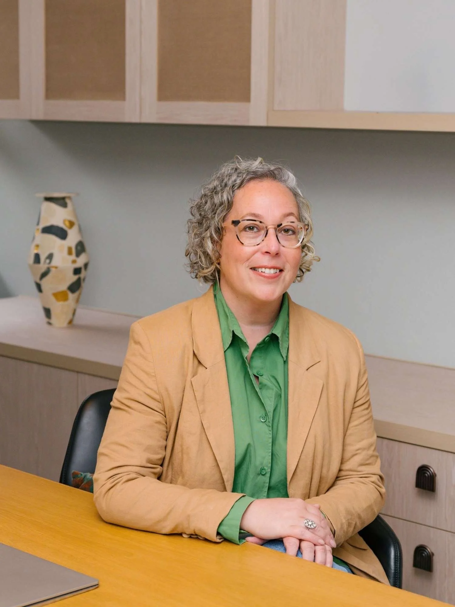 Hannah from Small Circle, a career coach and strategist, sitting at a desk in a professional workspace.