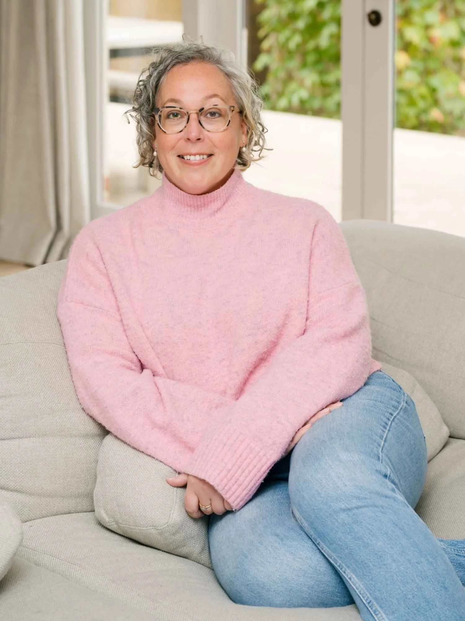 Hannah from Small Circle, a career coach and strategist, sitting on a couch in a relaxed professional setting.