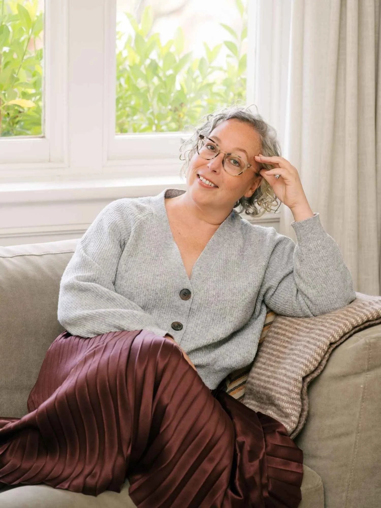 Hannah from Small Circle, a career coach and strategist, sitting on a couch in a relaxed professional setting.