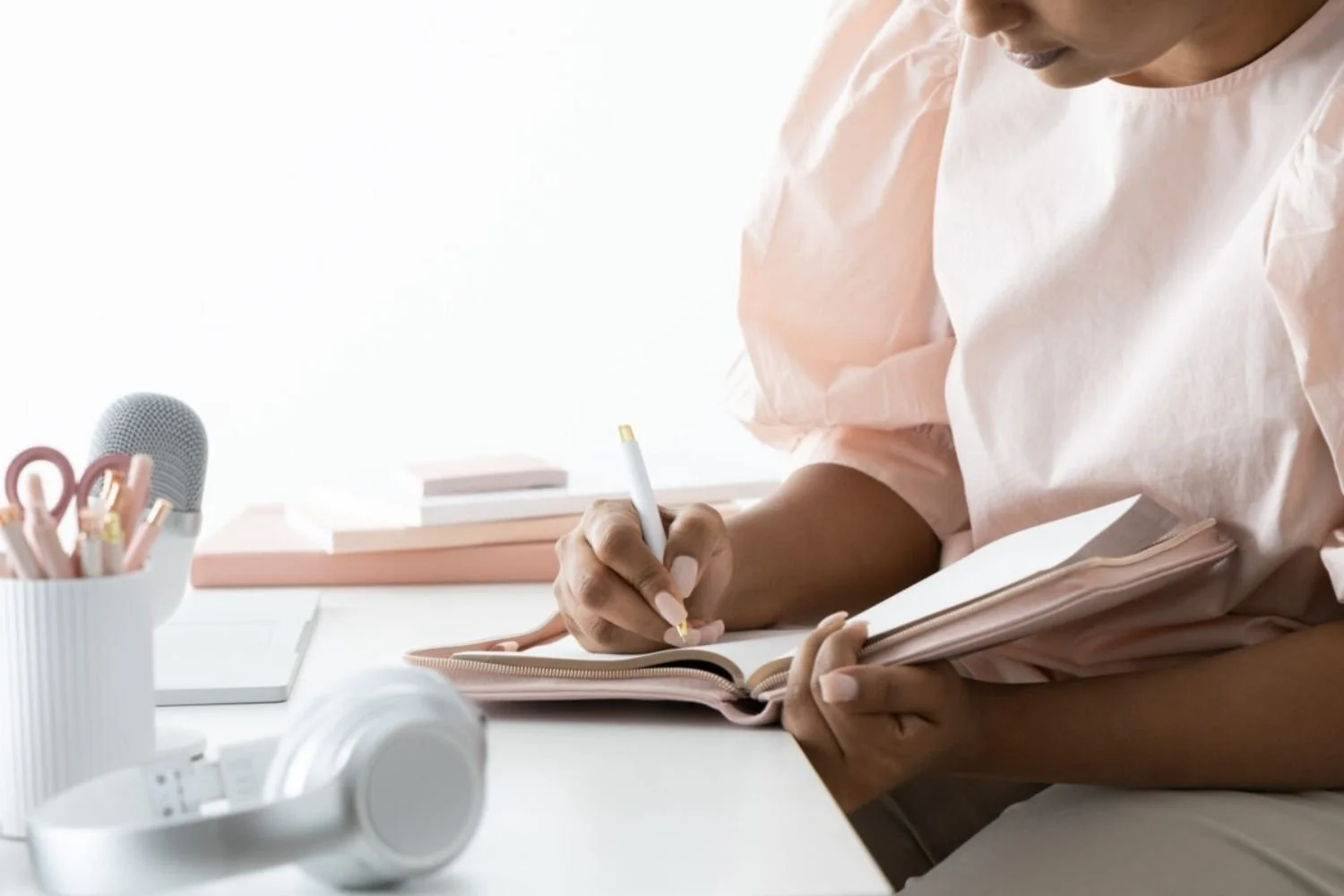 Person writing in a notebook for professional branding and career development planning.