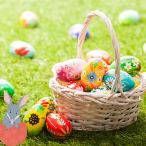 Wicker basket of colorful, patterned Easter eggs on green grass, surrounded by more eggs. Cartoon bunny in corner adds playful mood.