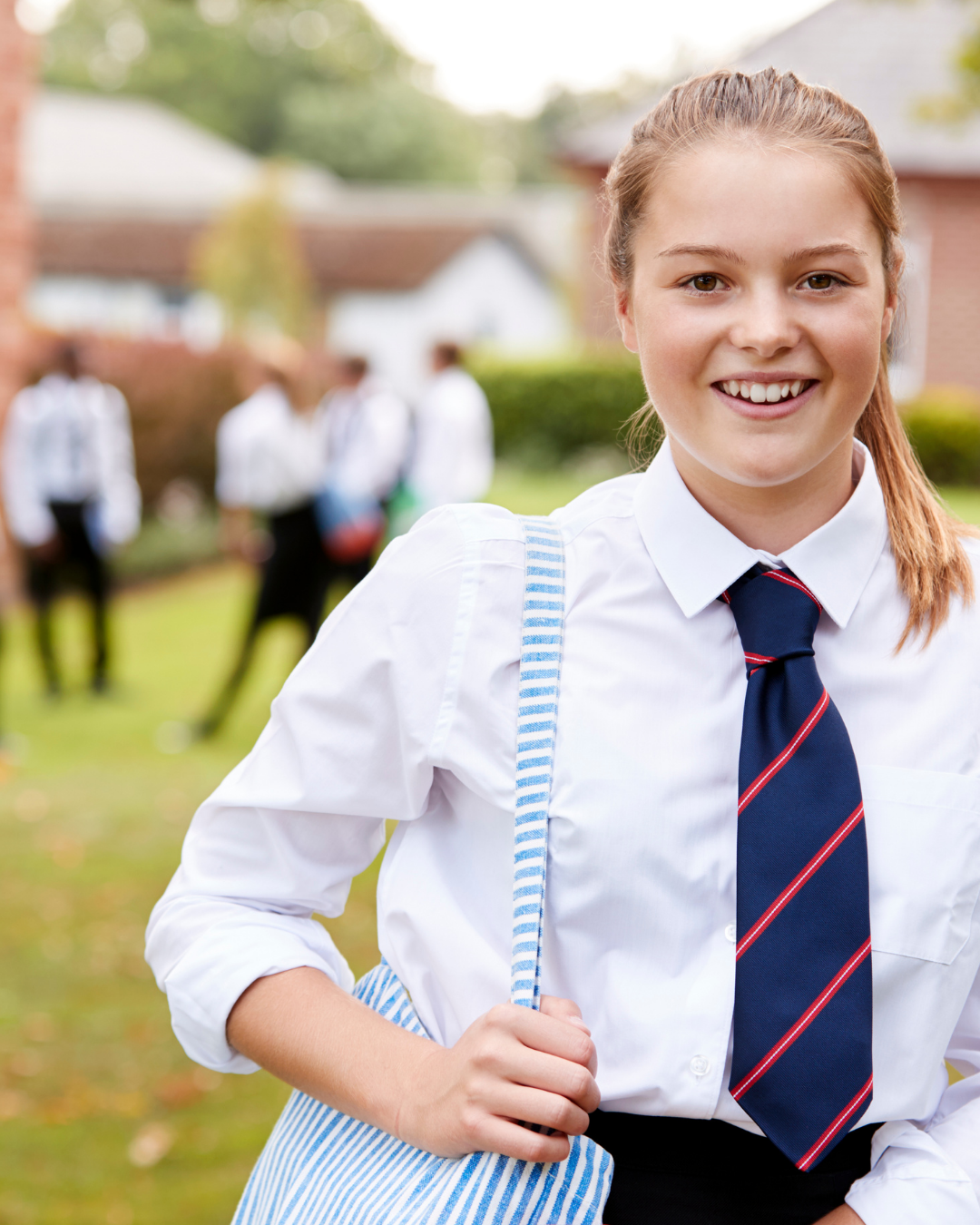 Smiling high school student in uniform carrying a bag on a school oval — VCE French tutoring and oral exam preparation in Melbourne