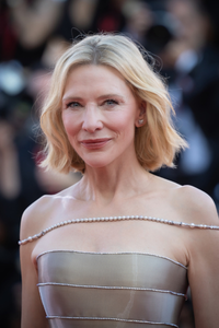 Australian actress Cate Blanchett on the red carpet, wearing an elegant silver off-the-shoulder gown.