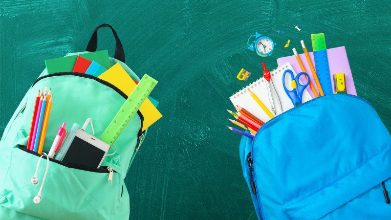 Two backpacks, one mint green and one blue, filled with school supplies like pencils, rulers, and notebooks, against a green chalkboard background.