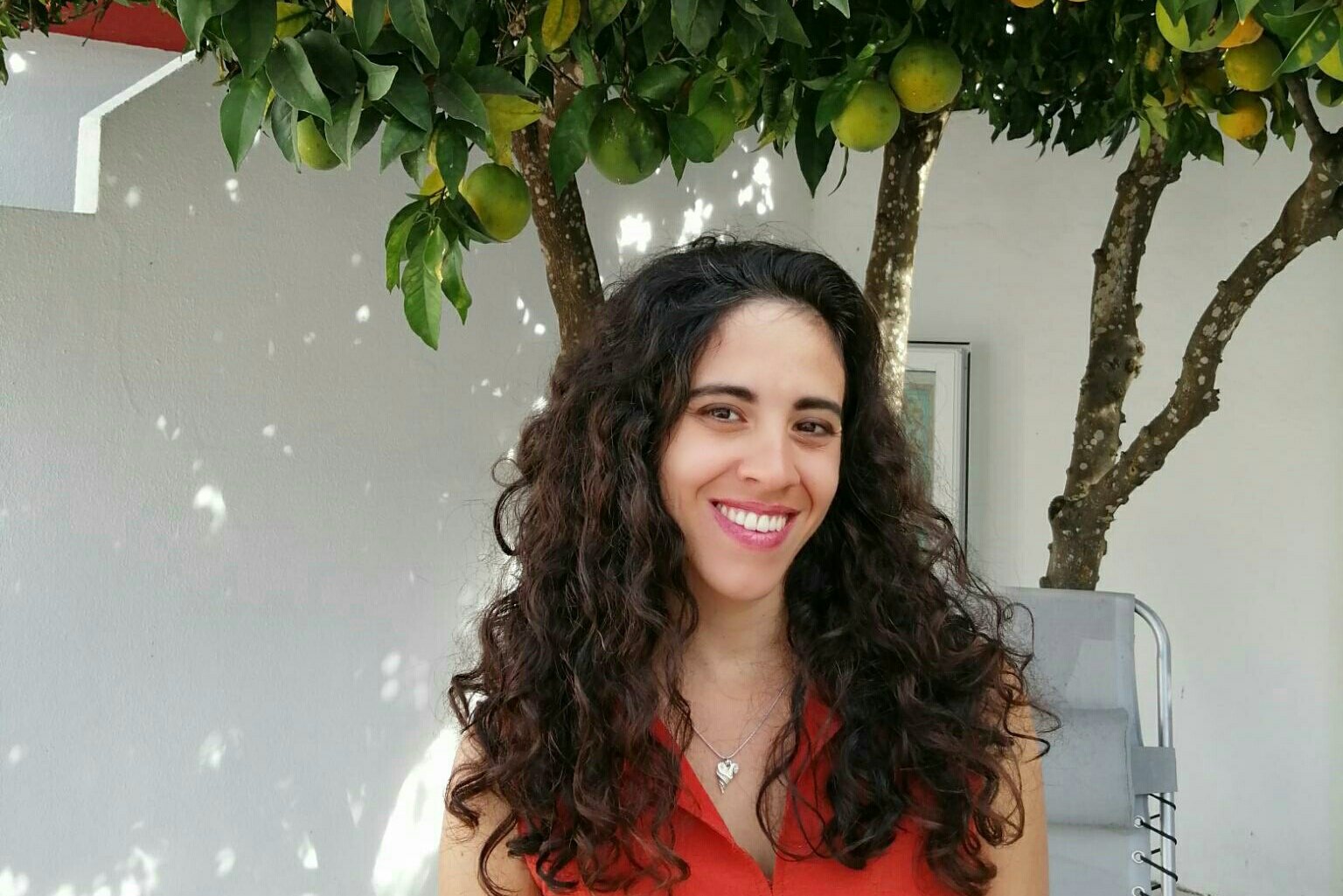 Matilde, French teacher at Sophie French Tutor, smiling outdoors under a citrus tree