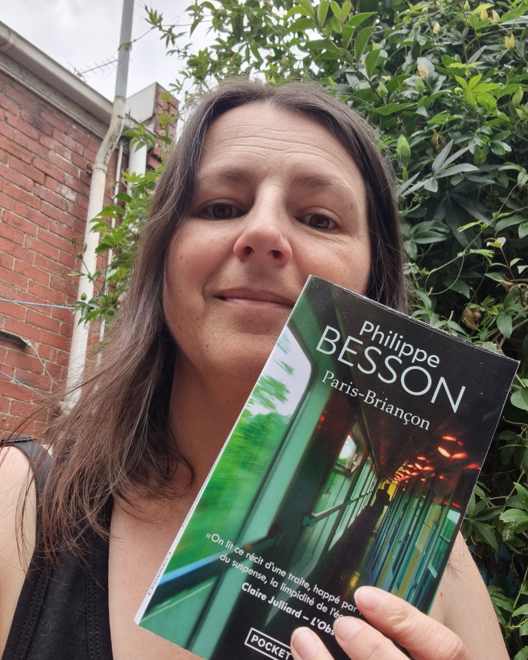 Sophie, founder of Sophie French Tutor, holding a copy of Paris-Briançon by Philippe Besson — French book club for adults in Melbourne