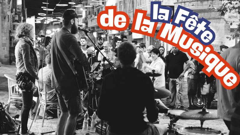 Street musicians perform at night with a lively crowd. Text  la Fête de la Musique" overlays the scene. Strings of light hang above.