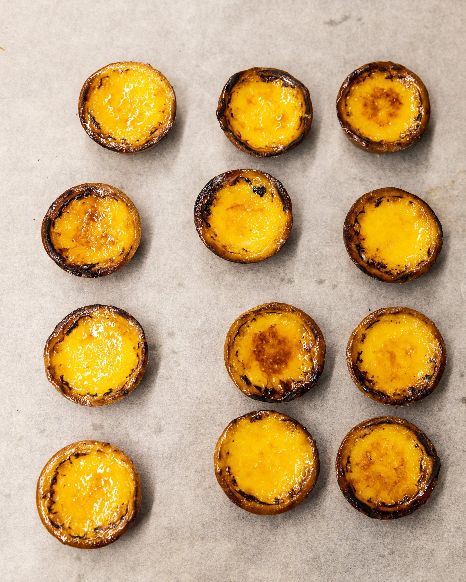 A group of grilled egg yolks with crispy edges on a baking sheet.