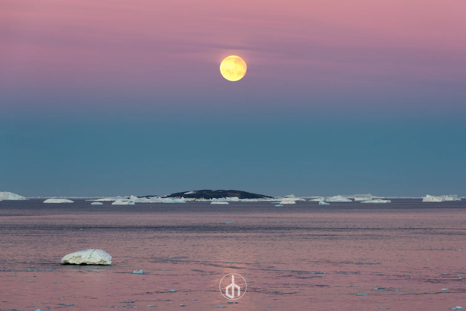 A full moon in a pink and purple sky over an icy landscape with floating icebergs and a distant land mass.