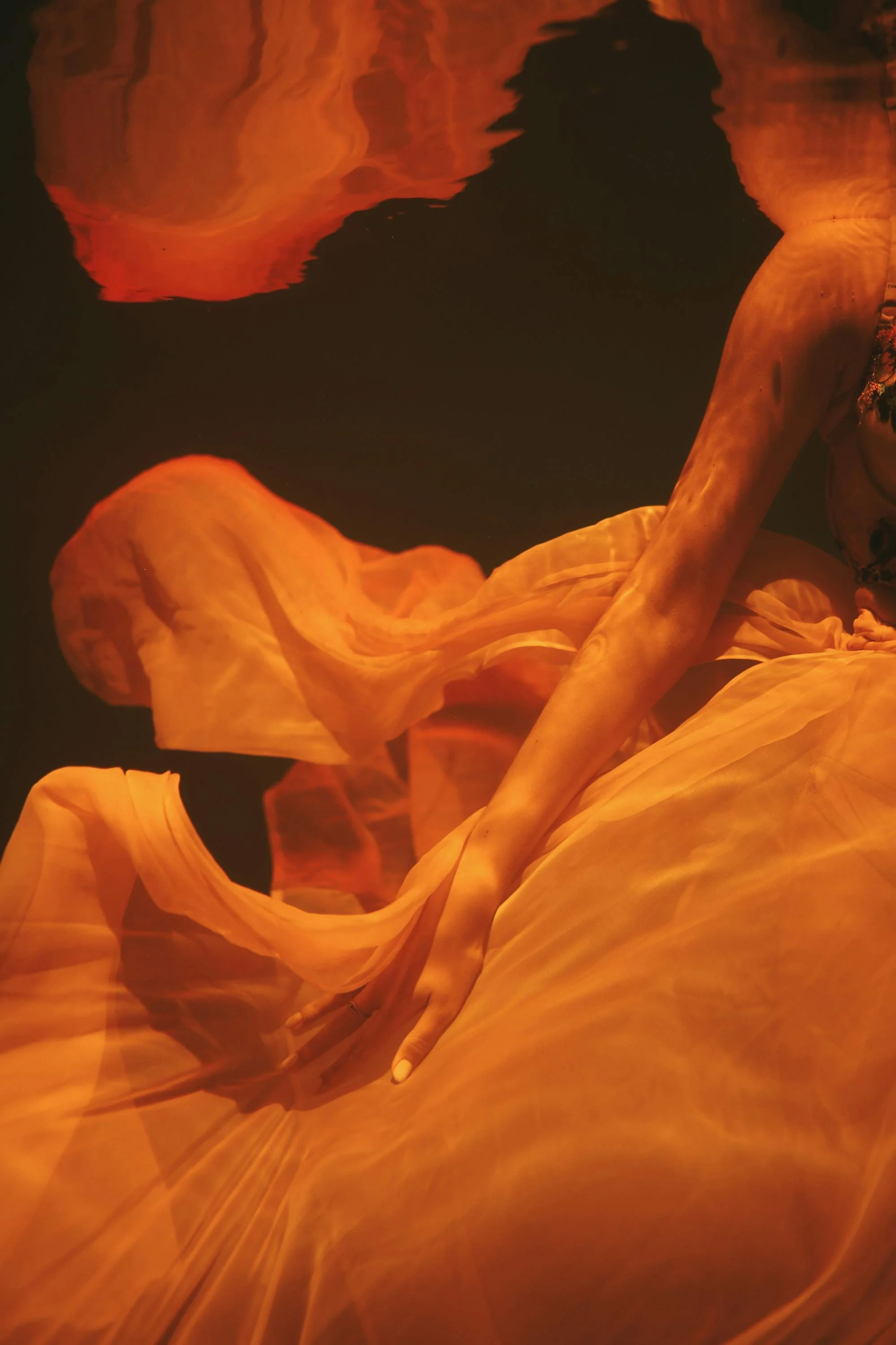 Flowing, orange and yellow fabric with a dark background.