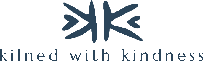 A logo featuring a stylized blue butterfly above the words 'kinned with kindness' in lowercase letters.