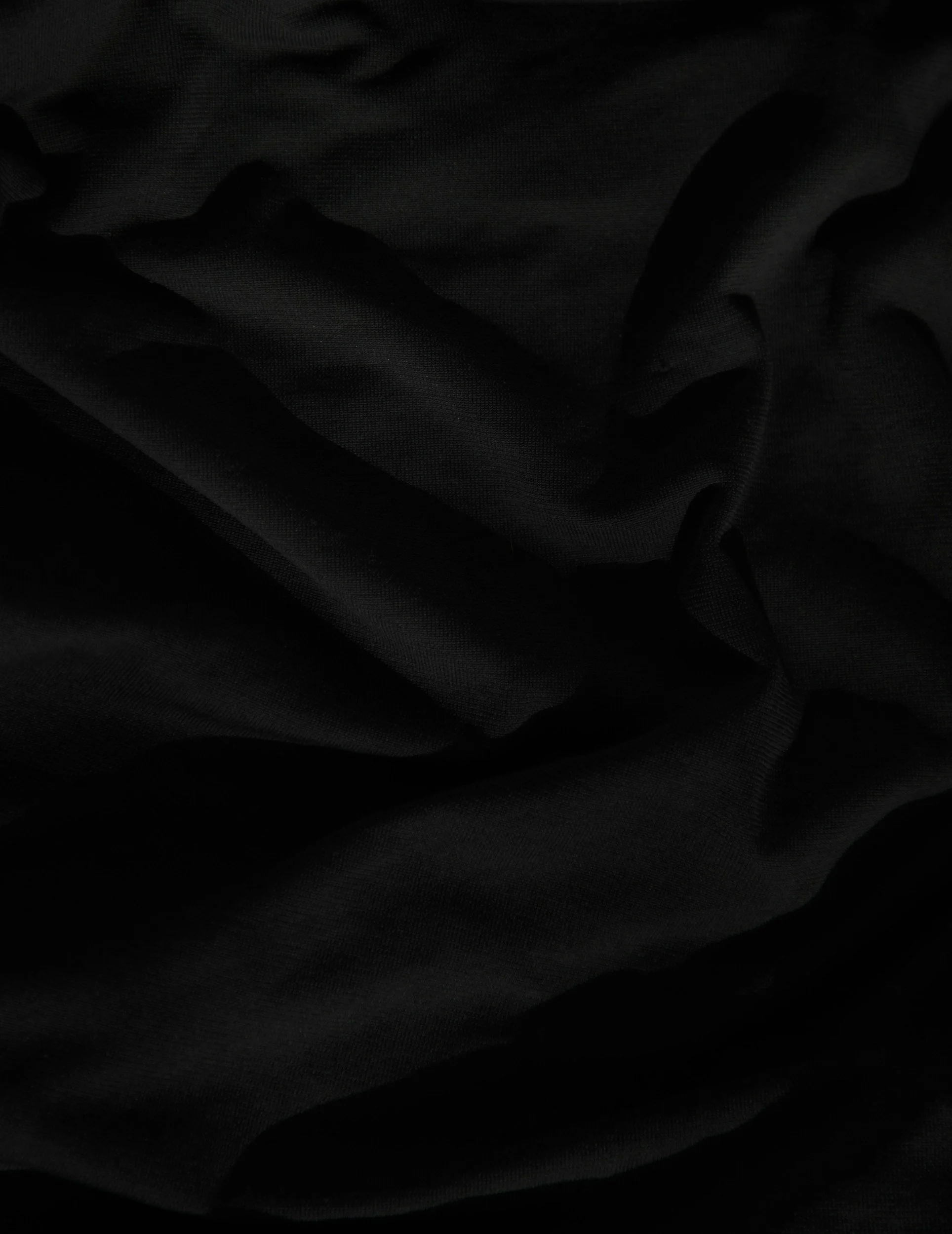 Close-up view of black fabric with folds and texture.