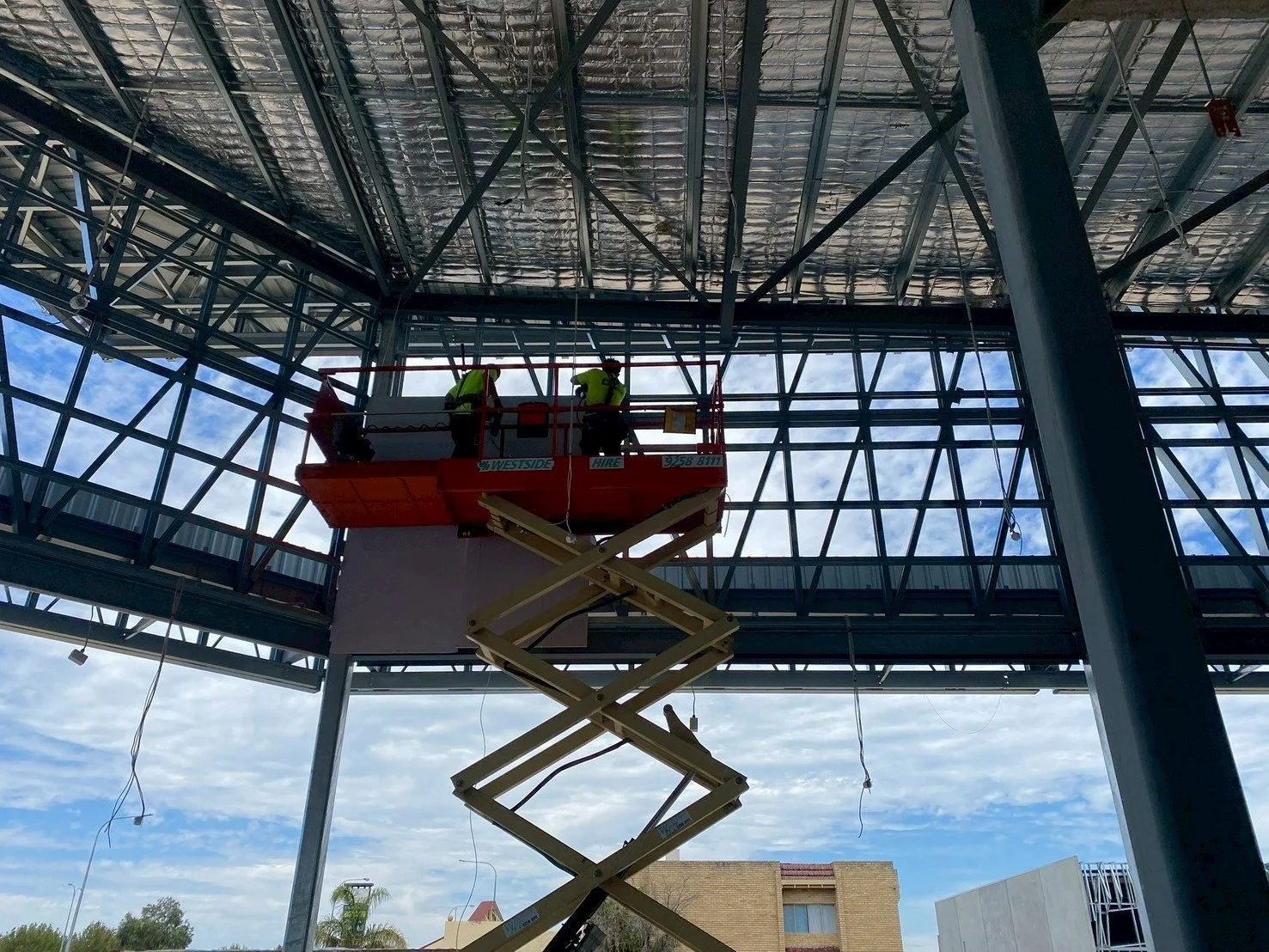 Construction workers on a lift working inside 