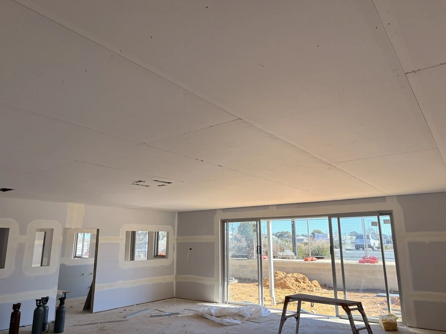 a room under construction with drywall panels on the ceiling and walls, 