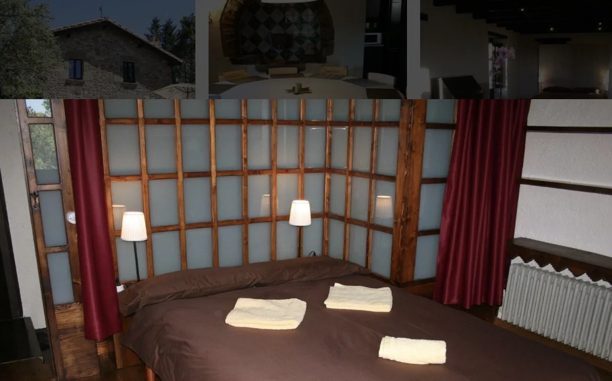 Habitación con cama doble, paredes de madera, cortinas rojas, lámparas de pared y toallas en la cama.