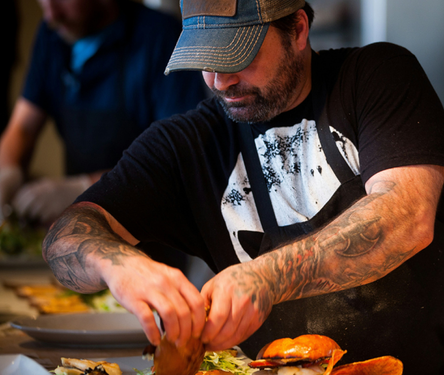 Head chef preparing and plating dishes during service in a busy Melbourne restaurant kitchen