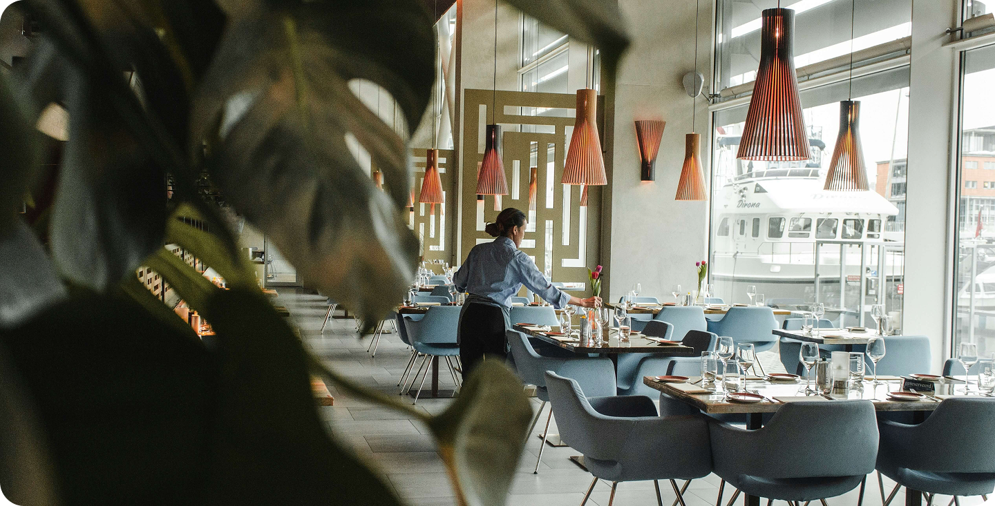 Venue manager setting tables in a premium Melbourne restaurant before service