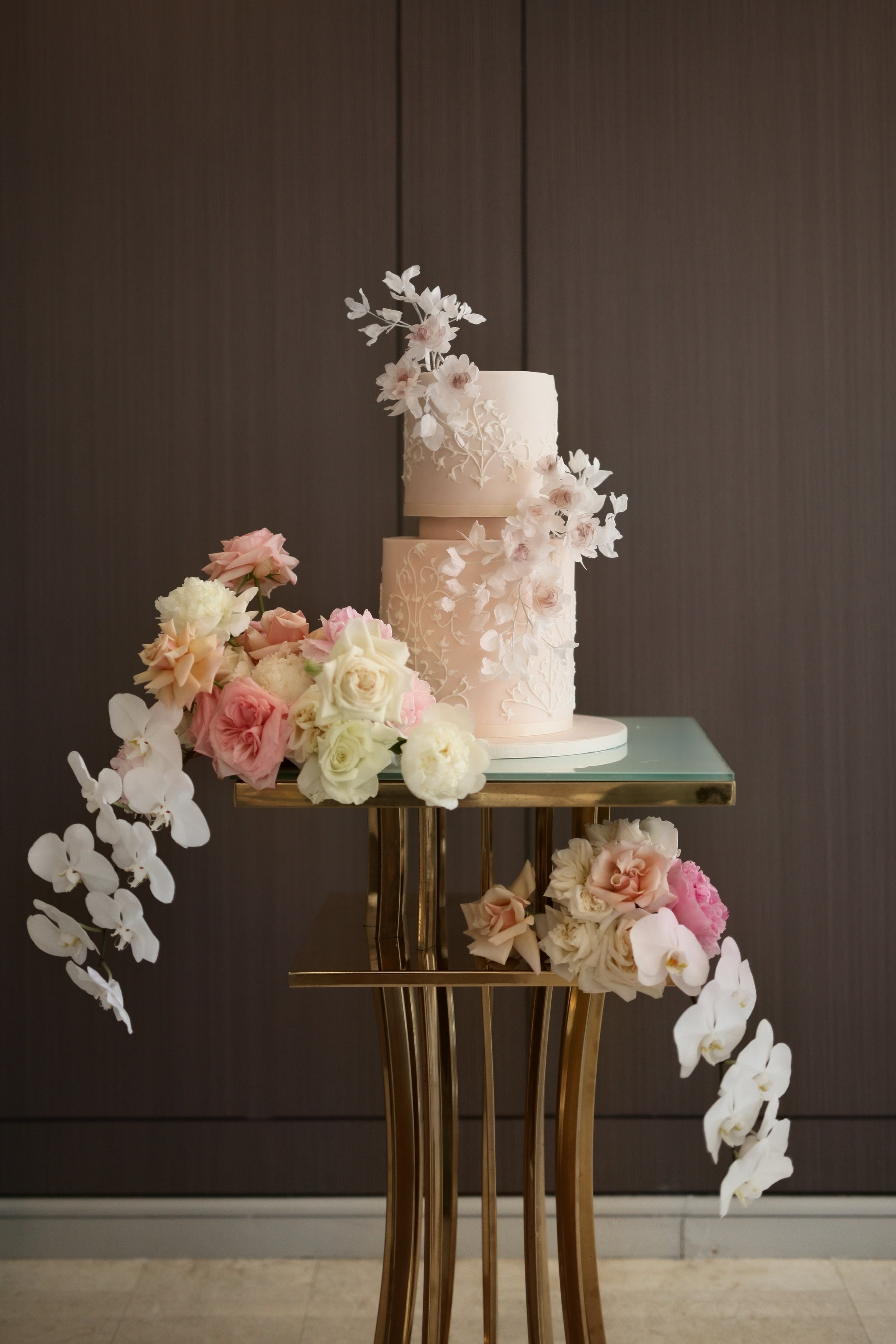 Elegant white wedding cake with cascading pink, white and lavender sugar flowers.