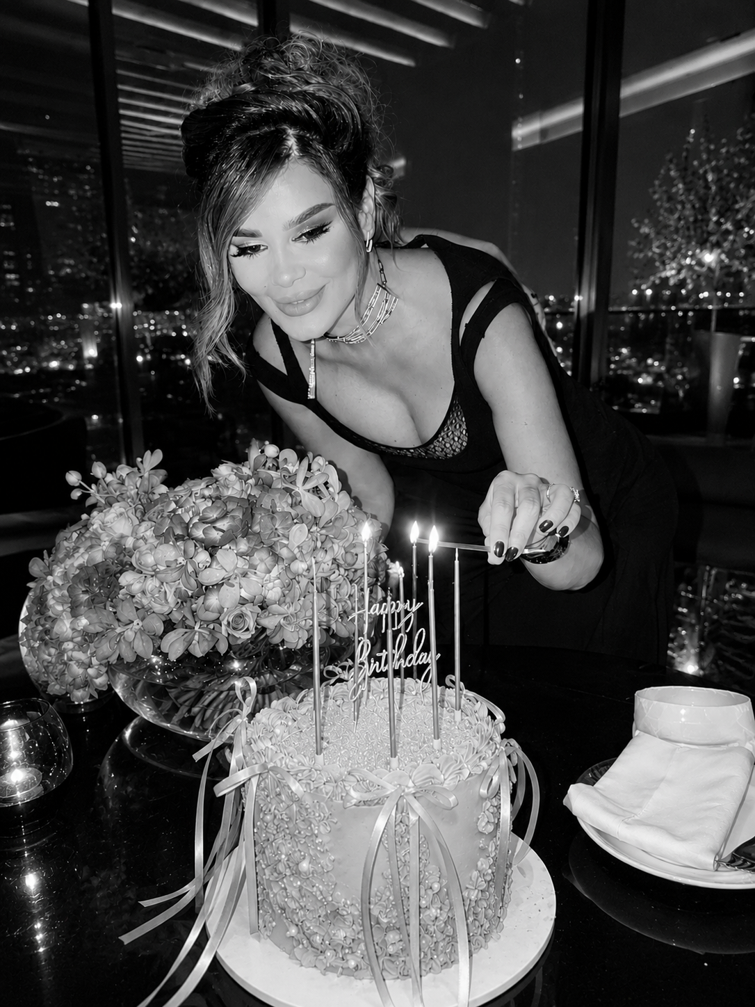 Elegant birthday cake with candles and floral details at an intimate celebration with Jwana Karim.