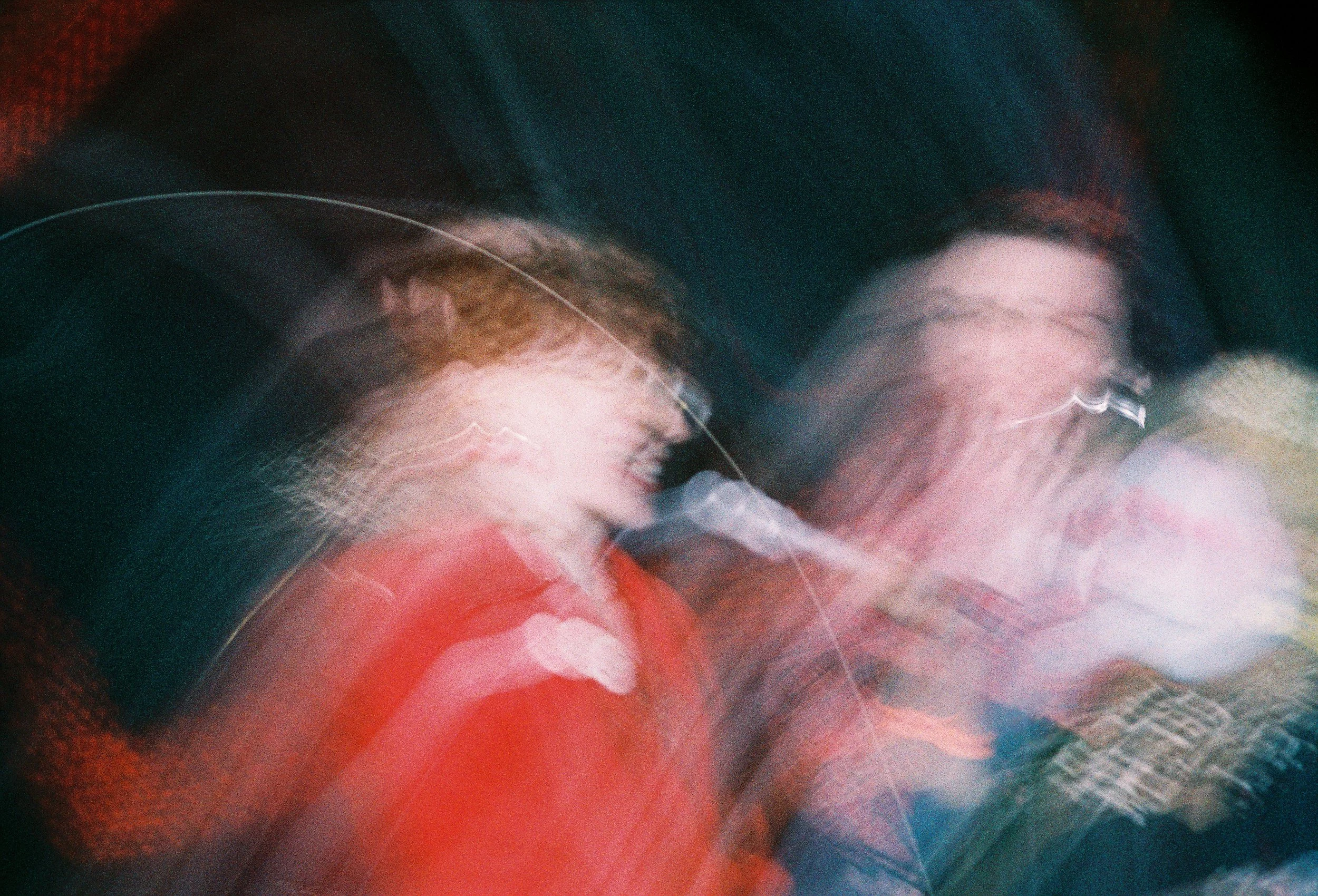 Abstract motion-blurred image with swirling colors of red, blue, and green, resembling a dynamic, artistic motion effect.