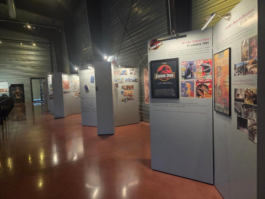 Exposition dans un musée sur Jurassic Park et l'ère des dinosaures, avec affiches et panneaux éducatifs.