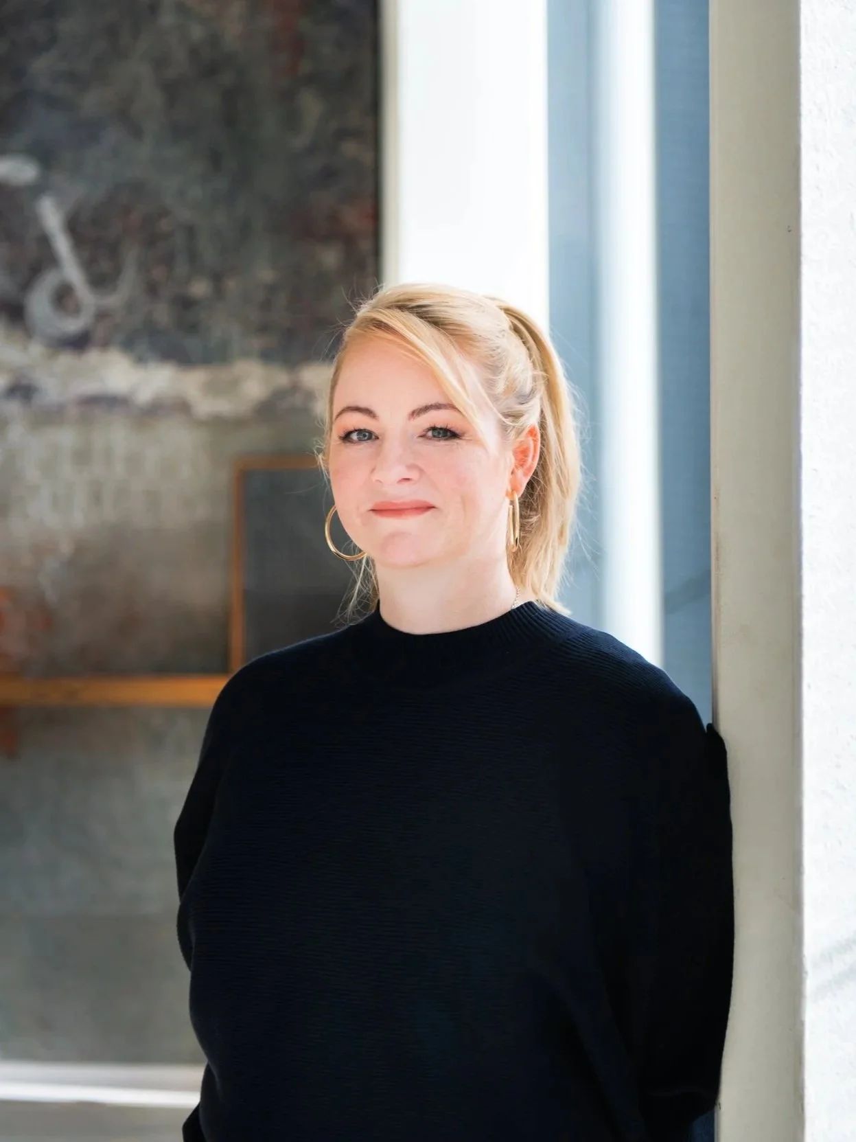 Raquel Dukic wearing a black shirt with her hair tied up.