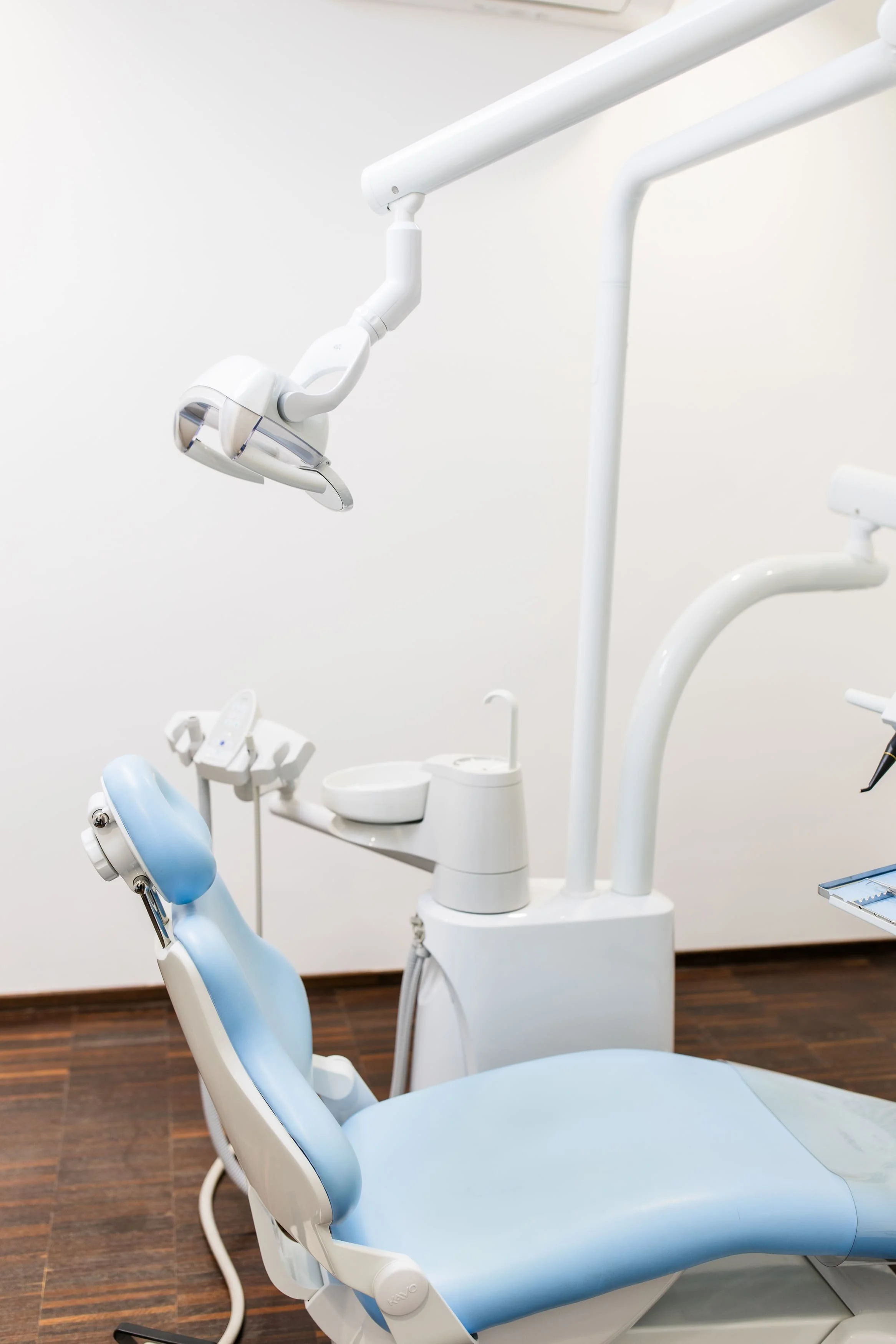 Zahnärztlicher Behandlungsstuhl in einem Behandlungszimmer, mit medizinischen Geräten und Armaturen.