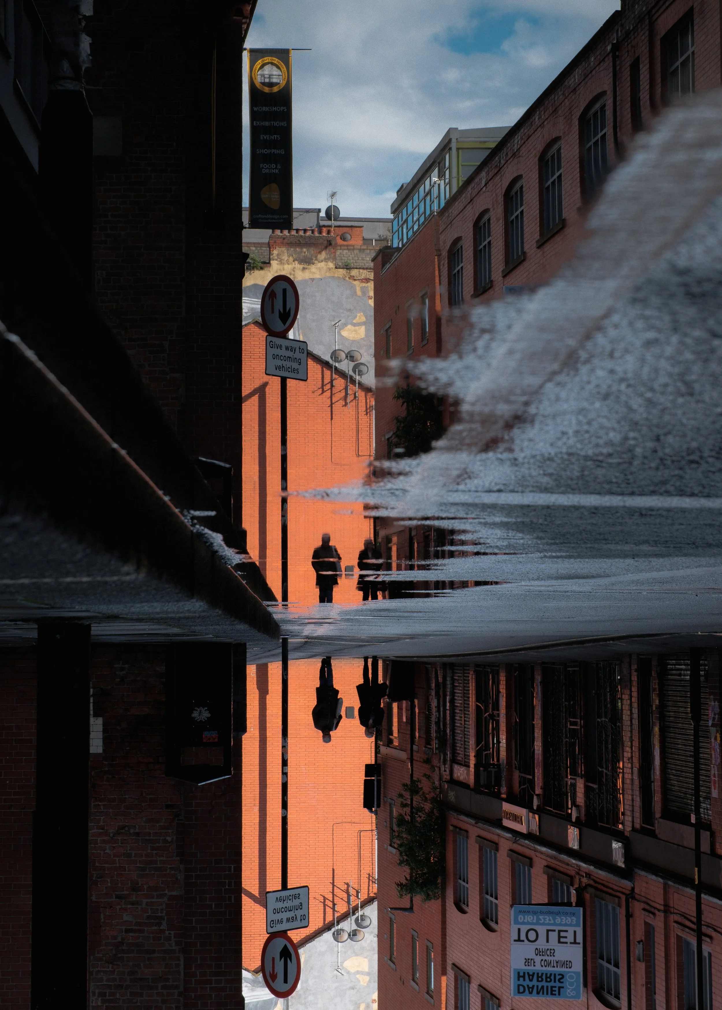 Silhouettes of people captured in a puddle