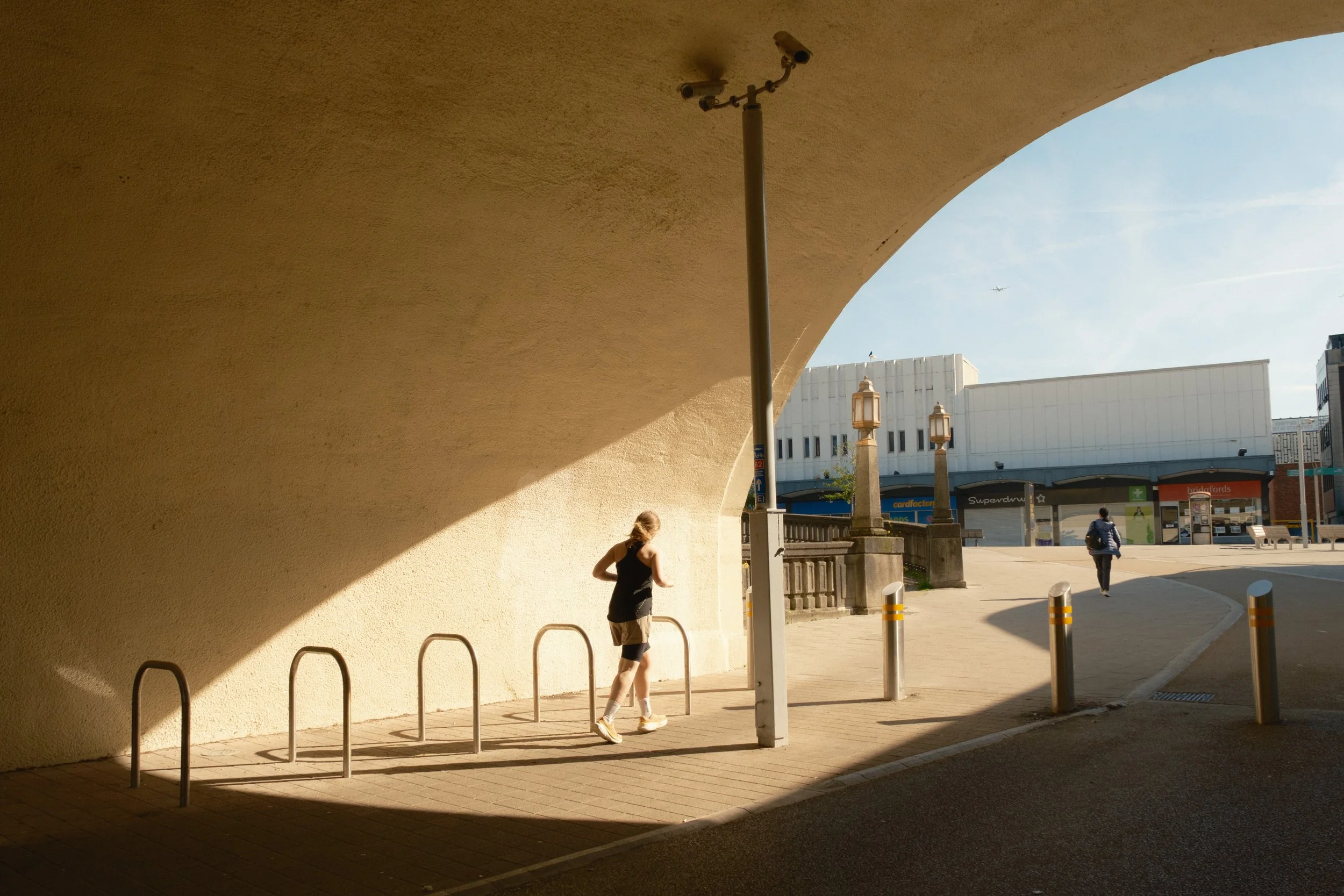A woman runs through a partially lit tunnel into Stockport's town centre