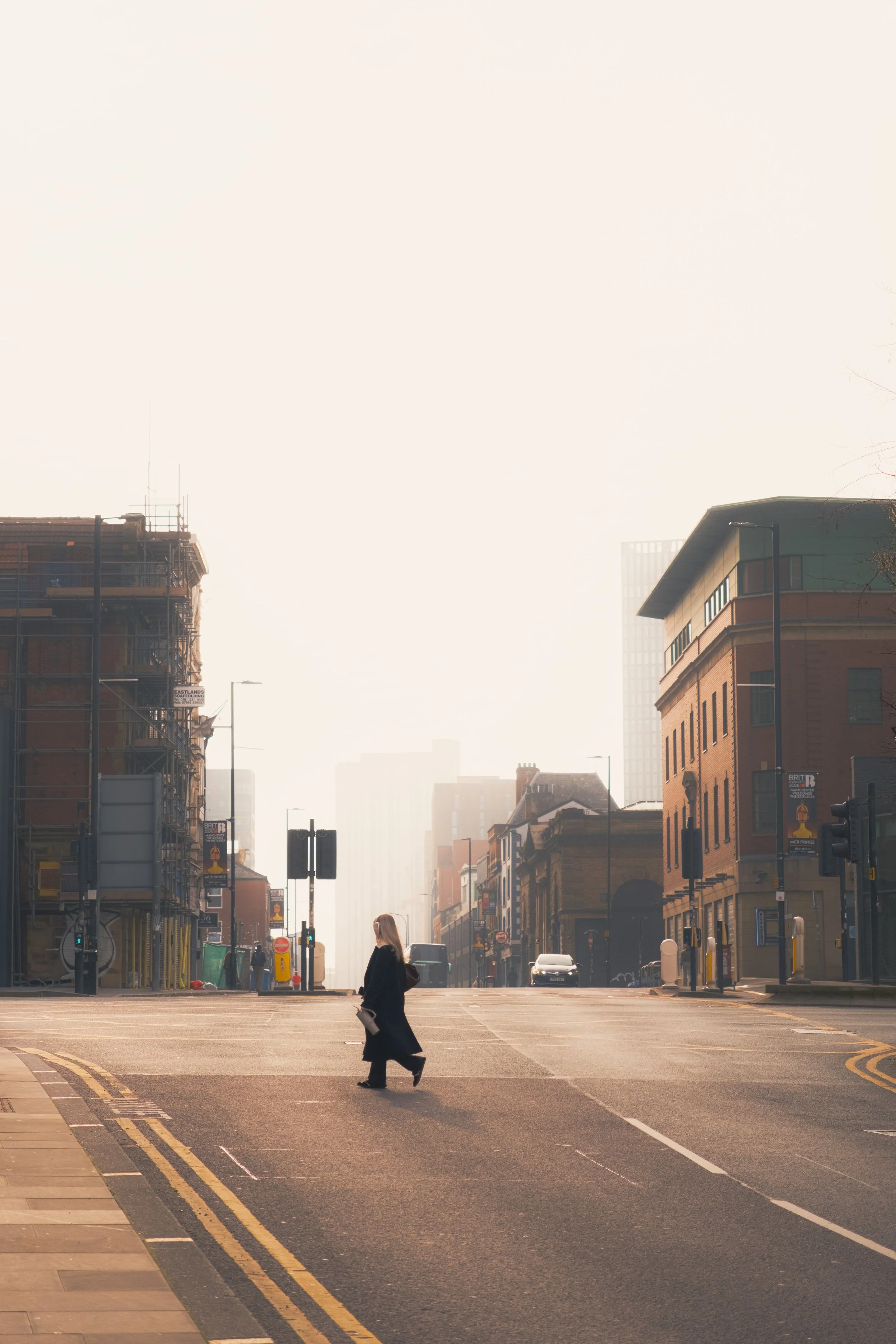 Woman crosses the road on a hazy morning