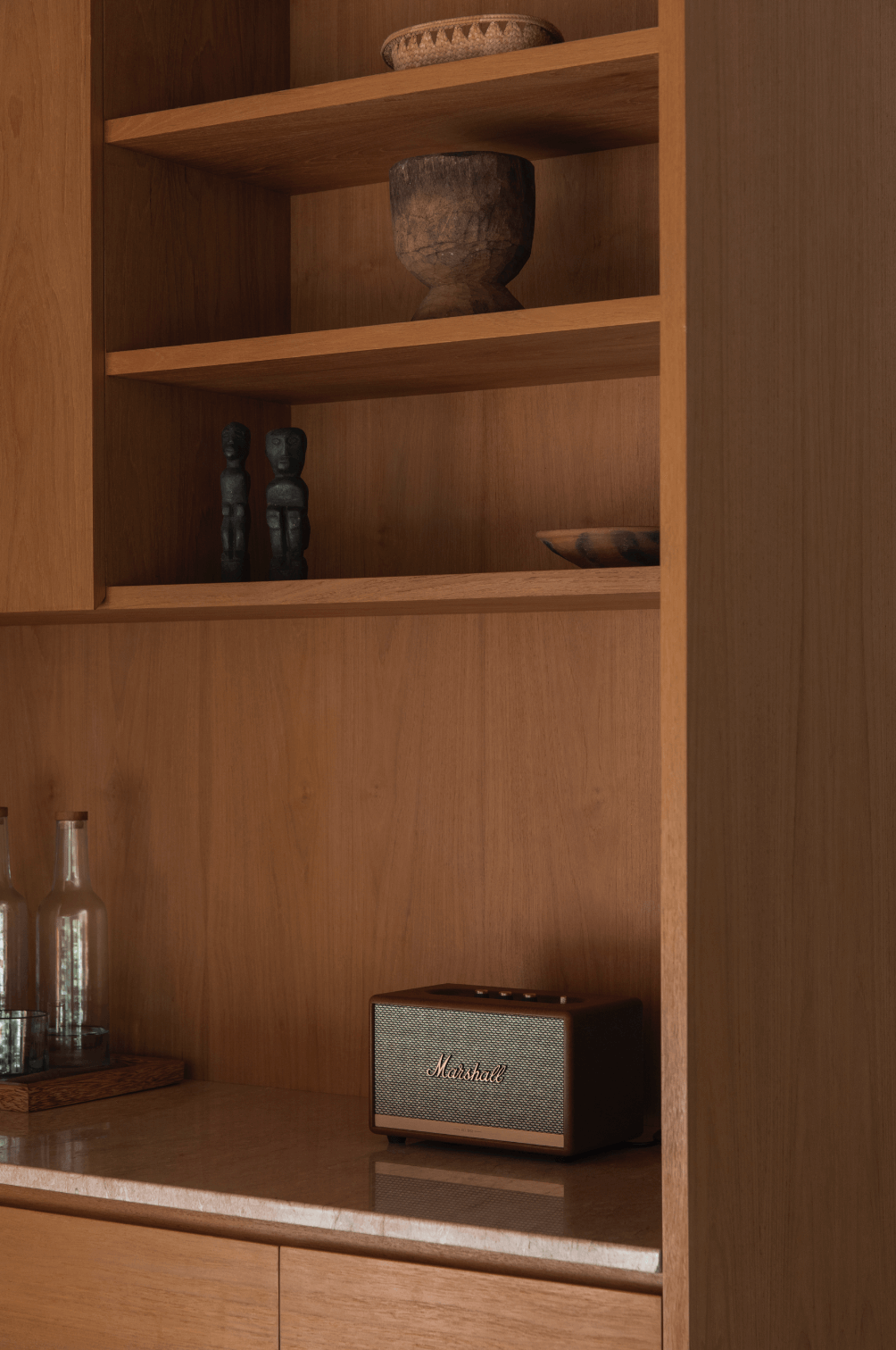 Wooden bookshelf with decorative items and a Marshall speaker