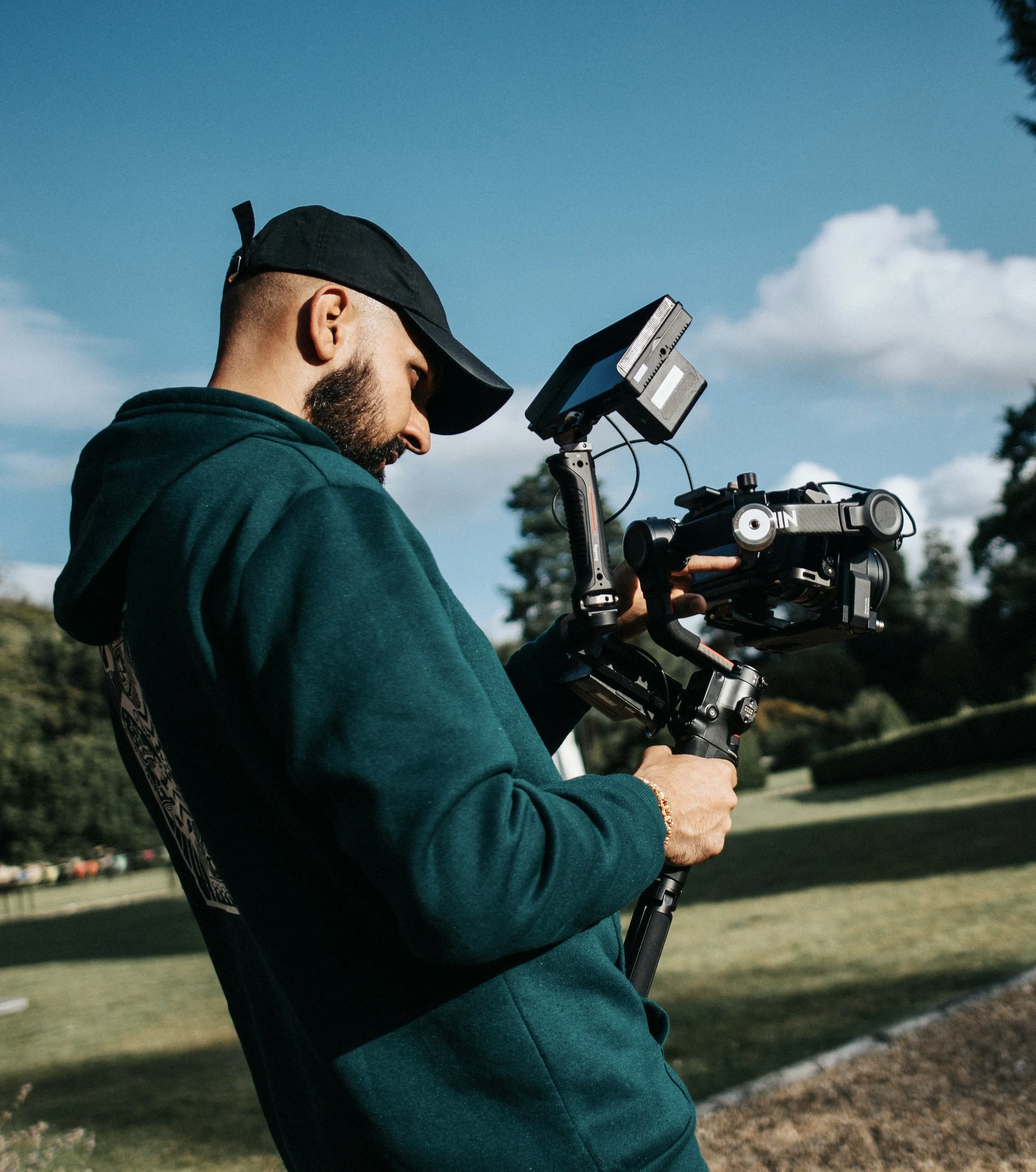 Filmmaker operating a cinema camera rig outdoors.
