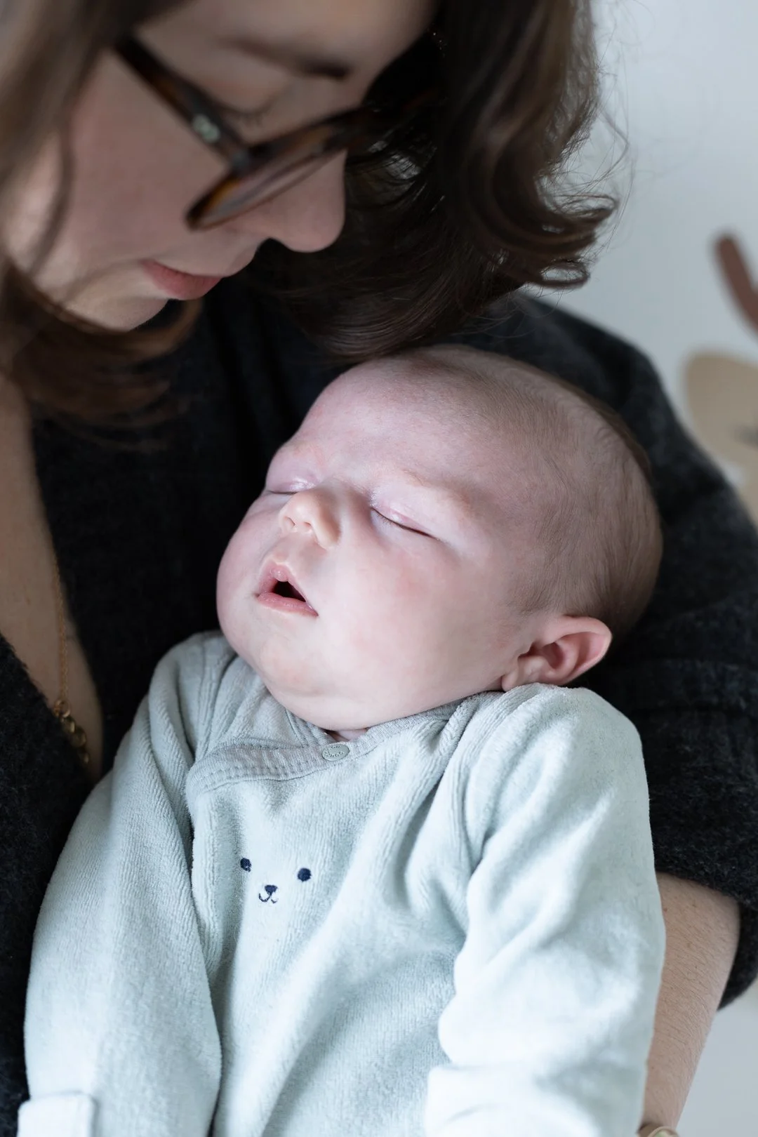 Une femme porte un bébé endormi contre sa poitrine.