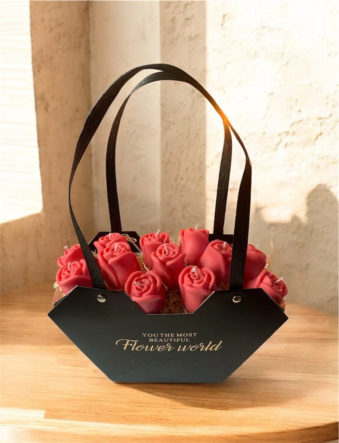 Korb mit roten Rosen-Teelichtern auf Holzoberfläche, Schriftzug "You the most beautiful flower world" auf Korb