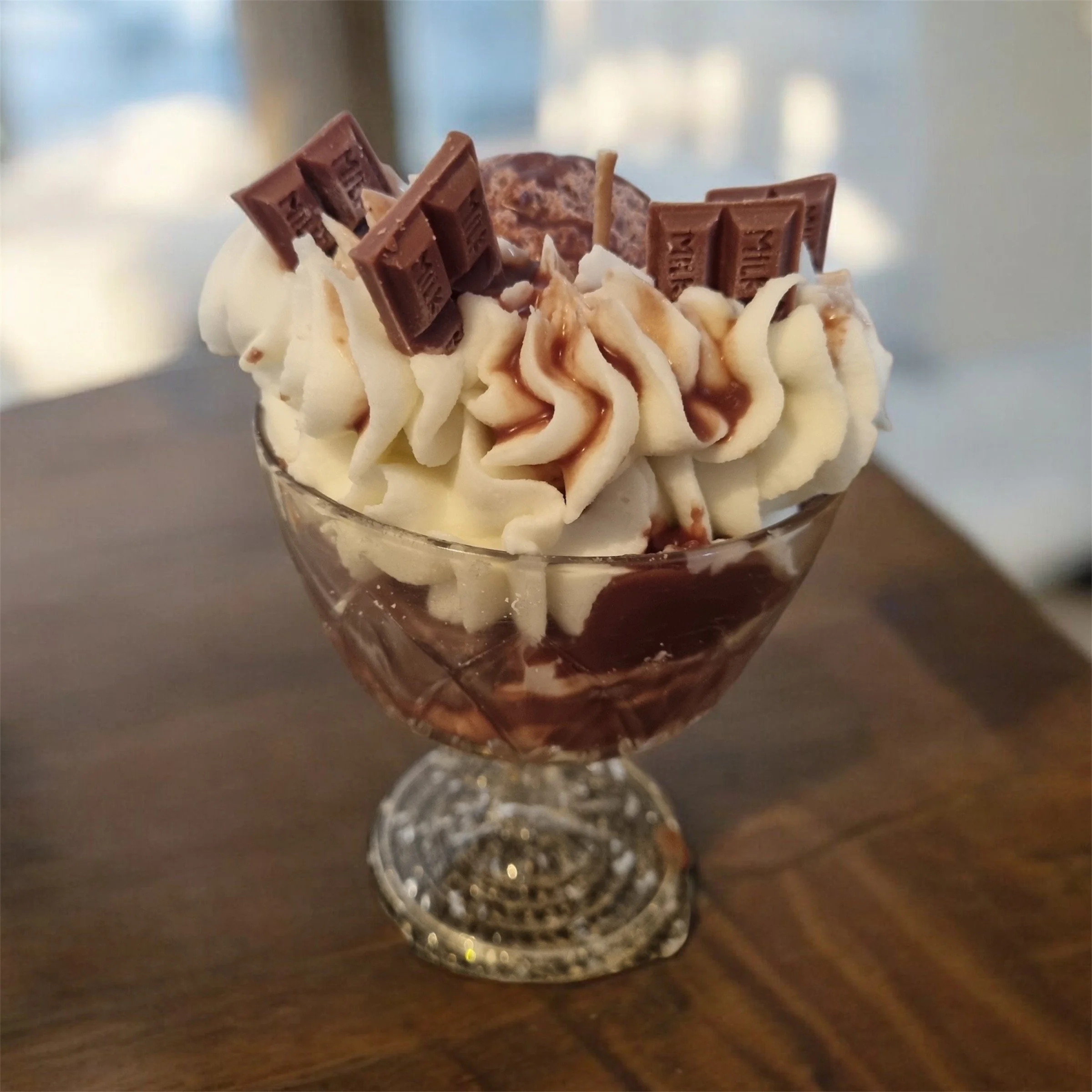 Ein Dessert mit Schokoladentafeln, Sahne, Haselnüssen und Karamell in einem Glas serviert.