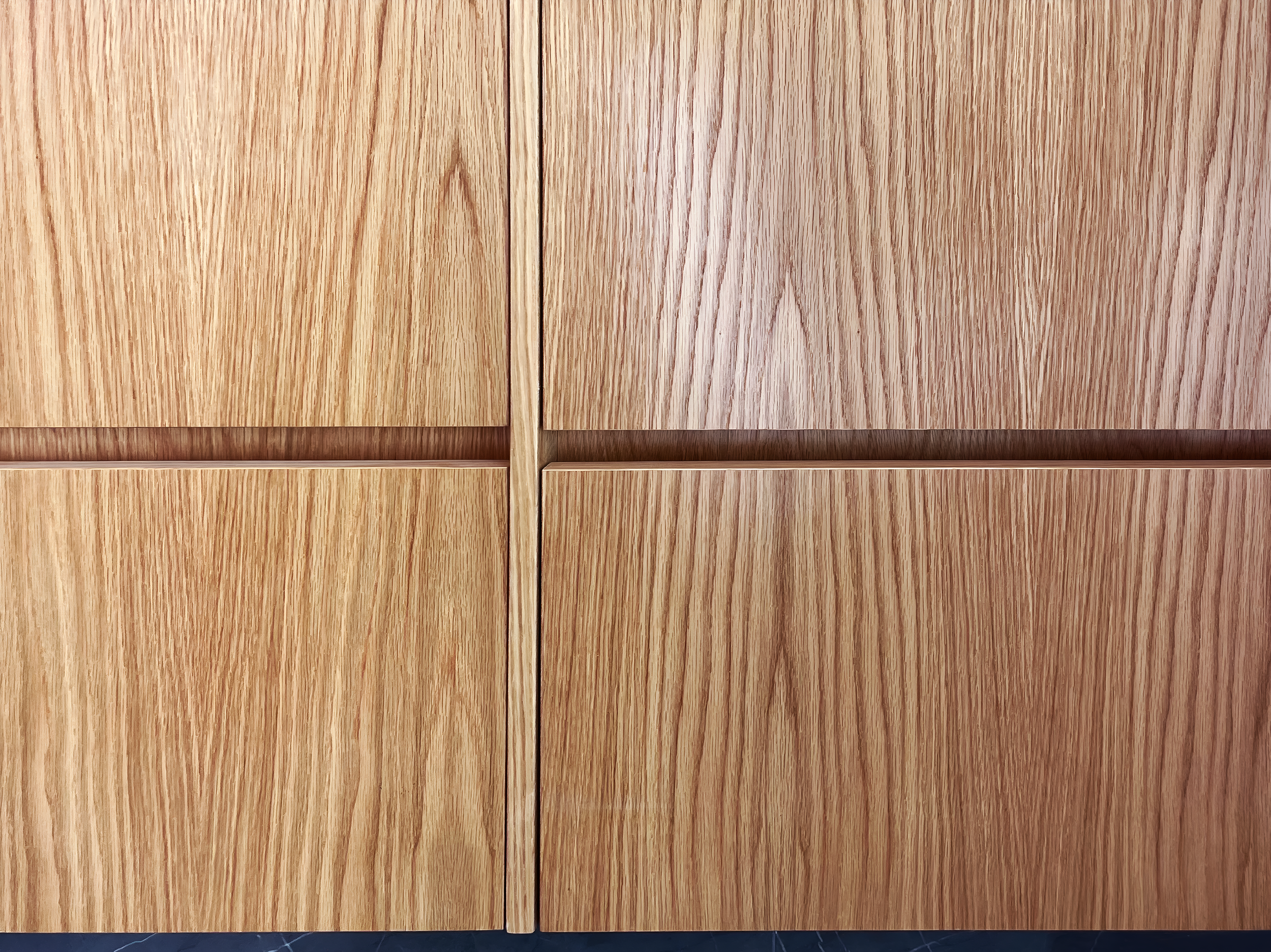 Close-up of a wooden cabinet with vertical grain patterns and a light brown finish.